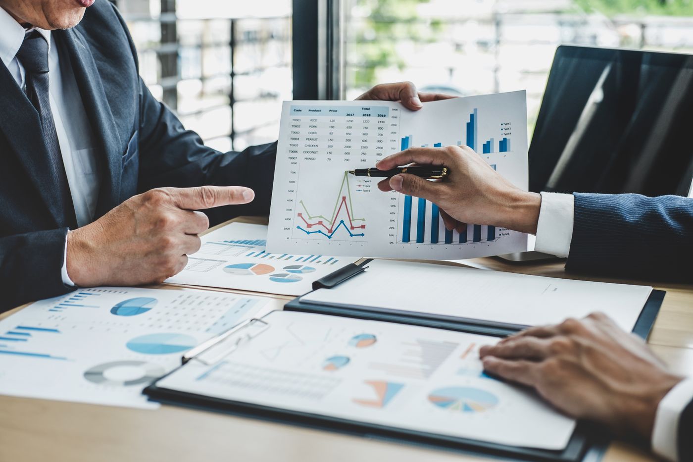 Real estate investor reviewing property analysis and financial planning documents at a desk