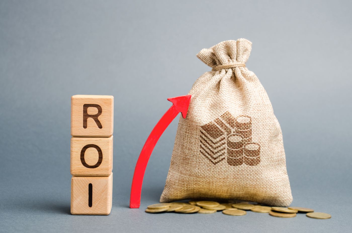 Concept image showing a rising ROI arrow with a bag of money, representing increasing returns on a real estate investment through leverage